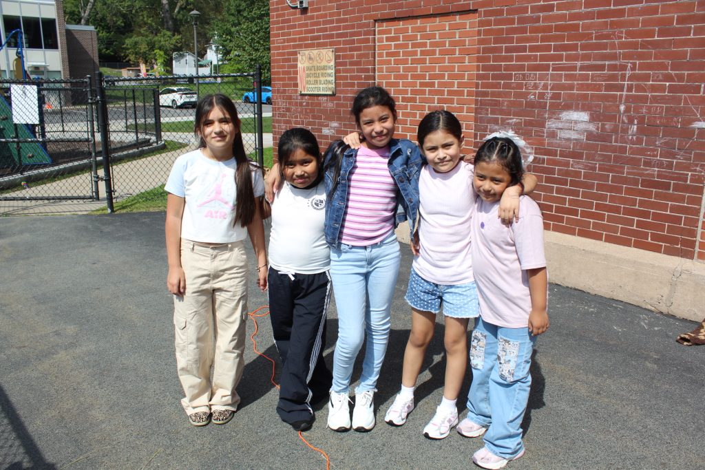 elementary students standing together smiling posing for camera