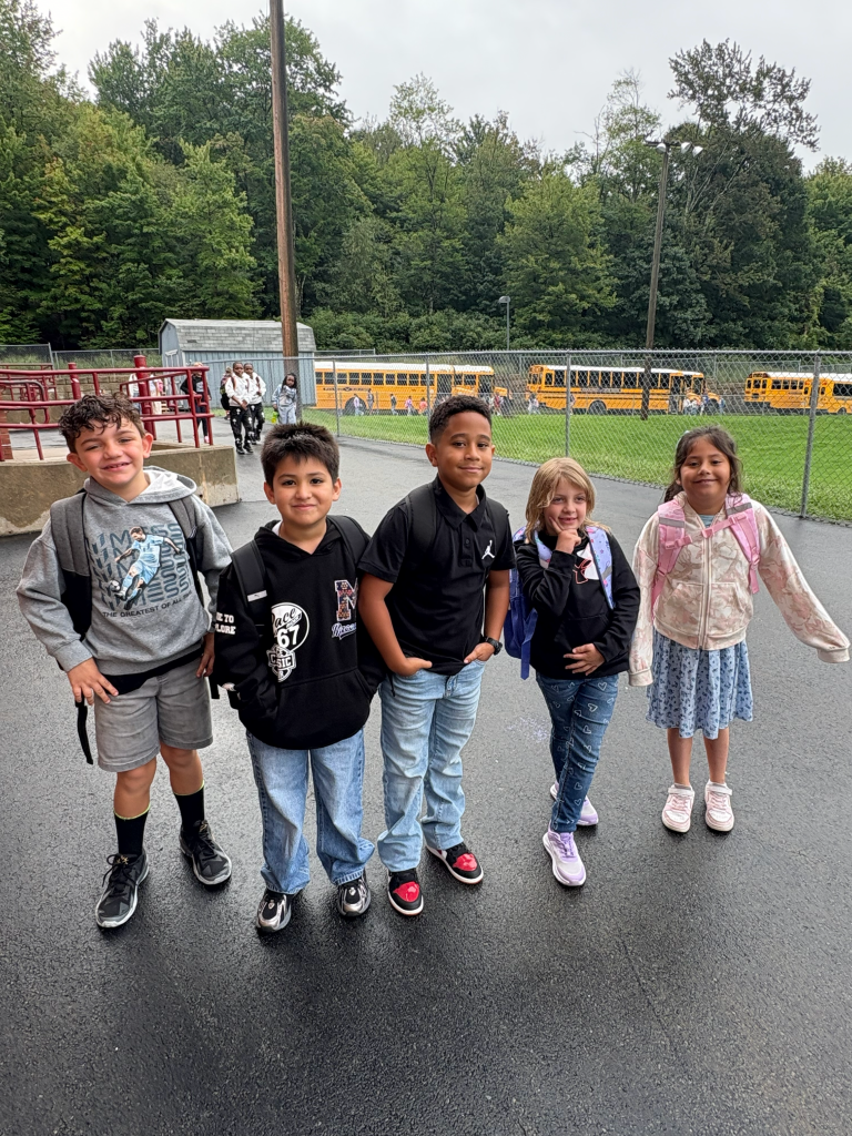 five elementary students ourtside standing and smiling for camera