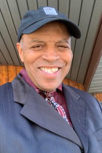 portrait shot of samuel sanders jr, an alumni of liberty, honoree of wall of fame. wearing a coat and hat, smiling