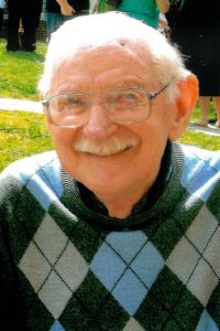 albert van dyke, alumni of liberty and honoree of wall of fame, wearing a sweater, and glasses, smiling and facing camera